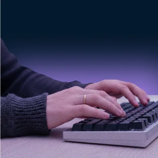 Photo of a person typing on a keyboard